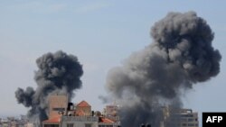 TOPSHOT - Smoke billows from residential buildings following Israeli airstrikes in Gaza City on October 7, 2023.
