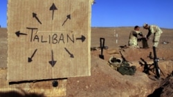 រូប​ឯកសារ៖ ទាហាន​ជើង​ទឹក​សហរដ្ឋ​អាមេរិក​កំពុង​នាំគ្នា​ច្រក​បាវ​ខ្សាច់​នៅ​មូលដ្ឋាន​យោធា​មួយ​នៅ​ក្បែរ​ស្លាកសញ្ញា​មួយ​ដែល​រំឭក​ដល់​គ្រប់គ្នា​ថា កងកម្លាំង​តាលីបង់​អាច​នៅ​គ្រប់​ទីកន្លែង ​ប្រទេស​អាហ្វហ្គានីស្ថាន ថ្ងៃទី១ ខែធ្នូ ឆ្នាំ២០០១។