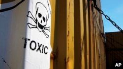 FILE - A sticker reading Toxic is seen on on containers carrying Syria's chemical weapons, on a Danish cargo ship, Ark Futura, transporting the shipment out of the strife-torn country, in Cyprus coastal waters, May 13, 2014. On Friday, Russia claimed it dismantled Syria's two remaining chemical weapons sites.