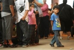 Niños hacen fila con algunos de los miles de jóvenes inmigrantes en el Navy Pier de Chicago el 15 de agosto del 2012.