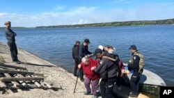 En esta imagen distribuida por la policía de Ucrania, agentes ayudan a evacuar a varias personas mayores tras un ataque ruso en las inmediaciones de la localidad de Vovchansk, en la región de Járkov, Ucrania, el 10 de mayo de 2024.
