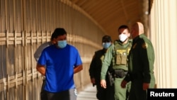 Migrantes bajo el programa de Protocolos de Protección al Migrante (MPP) son escoltados por agentes de la Patrulla Fronteriza de EE. UU. a través del Puente Fronterizo Internacional Lerdo Stanton para ser devueltos a México. 