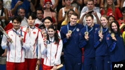 2024年8月3日，中國游泳隊(左)和美國游泳隊站在巴黎奧運頒獎台上。