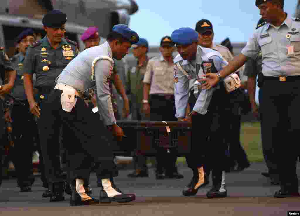 Indonesian Air Force soldiers carry the box containing the cockpit voice recorder of AirAsia 8501 at Iskandar airbase in Pangkalan Bun, Central Kalimantan, Jan. 13, 2015.