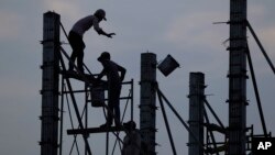 រូបឯកសារ៖ នៅ​ក្នុង​រូបភាព​ដែល​ថត​នៅ​ថ្ងៃ​ទី ២១ ខែមីនា ឆ្នាំ២០១៧ នេះ កម្មករ​សំណង់​កំពុងតែ ធ្វើការ​នៅក្នុង​ការដ្ឋាន​សំណង់​មួយ​នៅ​ជាយ​ក្រុង​ភ្នំពេញ នៃ​ប្រទេស​កម្ពុជា។ (AP)