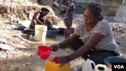 A woman mixes Clorox with water to drink in Port-au-Prince, Haiti, on April 3, 2020. Some Haitians believe the mixture can prevent them from COVID-19 infection.