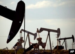 FILE - In this April 24, 2015, photo, pumpjacks work in a field near Lovington, N.M. Some studies show that the production of natural gas from the earth releases methane gas into the atmosphere. (AP Photo/Charlie Riedel, File)