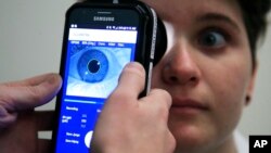 Clinical Research Assistant Kevin Jackson uses AlgometRx Platform Technology on Sarah Taylor's eyes to measure her degree of pain at the Children's National Medical Center in Washington, Monday, Dec. 10, 2018. Children's National Medical Center is testing an experimental device t