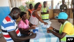 Les membres du personnel électoral comptent les bulletins de vote lors du dépouillement, lors des élections générales à Bissau, en Guinée-Bissau, le 18 mai 2014.