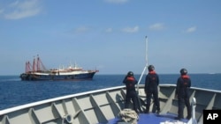 菲律宾海警队员2021年4月27日观察停靠在萨比纳浅滩的中国海上民兵船。（菲律宾海警队照片）