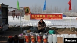 春節前北京一個露天廣場內一名男子在售賣桶裝白酒。（2025年1月22日）