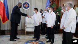 នៅ​ក្នុង​រូបថត​ដែល​ផ្ដល់​ឱ្យ​វិមាន​ប្រធានាធិបតី​ហ្វីលីពីន​នេះ បង្ហាញ​ពី​លោក Lloyd Austin (ឆ្វេង) រដ្ឋមន្ត្រី​​ការពារ​ប្រទេស​សហរដ្ឋ​អាមេរិក ចាប់​ដៃ​សម្ដែង​ការ​គួរសម​ជាមួយ​នឹង​ប្រធានាធិបតី​ហ្វីលីពីន លោក Rodrigo Duterte។