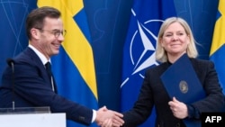 Švedski premijer Ulg Kristeršonn i liderka Socijaldemokrata Magdalena Anderšon razmjenjuju dokumenta na konferenciji za novinare o prijemu Švedske u NATO, 11. marta 2024. (Foto: AFP/TT NEWS AGENCY/Lars Schroder)