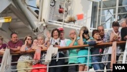 អ្នកដំណើរតាមនាវា Westerdam ឈរមើលការចាកចេញរបស់អ្នកដំណើរមួយចំនួន កាលពីព្រឹកថ្ងៃសុក្រ ទី១៤ ខែកុម្ភៈ ឆ្នាំ២០២០។ (ស៊ុន ណារិន/VOA)