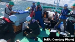 资料照片：2024年10月15日，来自中国、韩国和瑞士的专家在福岛第一核电站附近沿海进行水样采集。