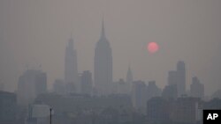 The sun rises over a hazy New York City skyline as seen from Jersey City, N.J., Wednesday, June 7, 2023. Intense Canadian wildfires are blanketing the northeastern U.S. in a dystopian haze, turning the air acrid, the sky yellowish gray and prompting warnings for vulnerable populations to stay inside. (AP Photo/Seth Wenig)