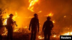ကယ်လီဖိုးနီးယားပြည်နယ် Santa Clarita မြို့မြောက်ဘက် Castaic ရေကန်ကြီးအနီး လောင်ကျွမ်းနေတဲ့ မီးများကို မီးသတ်သမားတွေက ငြှိမ်းသတ်နေစဉ် (ဇန်နဝါရီ ၂၂၊ ၂၀၂၅)