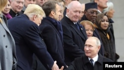 Le président russe Vladimir Poutine serre la main du président américain Donald Trump à l’occasion de sa commémoration du Jour de l’armistice, cent ans après la fin de la Première Guerre mondiale, à l’Arc de Triomphe, à Paris, le 11 novembre 2018.