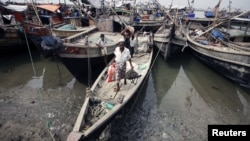 Burmeese displaced by recent violence carry their belongings as they arrive by boats to Thaechaung refugee camp, outside of Sittwe (formerly Akyab), the capital of Rakhine State, October 28, 2012. 
