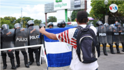 Un familiar de un preso político protesta con una bandera de Nicaragua en el parqueo de un hotel en Managua el 14 de septiembre de 2020. Foto de Houston Castillo, VOA.