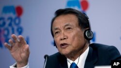 Mantan Perdana Menteri Jepang Taro Aso, saat masih menjabat sebagai Menteri Keuangan dalam konferensi pers usai Pertemuan Tahunan Bank Dunia/IMF di Washington, D.C., AS, 18 Oktober 2019. (AP Photo/Jose Luis Magana)