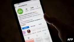 FILE - A woman checks a phone app reporting sexual harassment and misconduct allegedly committed by Ahmed Bassam Zaki, in Cairo, Egypt, July 15, 2020. 