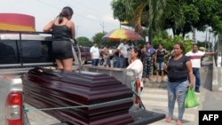 Familiares cargan en un camión el ataúd de una de las víctimas del tiroteo de la víspera en una cooperativa, luego de que los cuerpos fueran liberados del Laboratorio de Criminalística y Ciencias Forenses, en Guayaquil, Ecuador, el 31 de marzo de 2024.