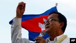 FILE - Cambodian opposition leader Sam Rainsy of the Cambodia National Rescue Party delivers a speech before his party supporters during a rally in Phnom Penh, Cambodia, Sunday, Dec. 22, 2013.