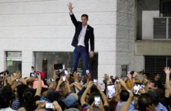 Opposition leader Juan Guaido waves to supporters during a rally at Bolivar Plaza in Chacao, Venezuela, Feb. 11, 2020.