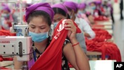 រូបឯកសារ៖ កម្មកររោងចក្រ​កម្ពុជាដេរ​​សម្លៀកបំពាក់​ក្នុង​រោងចក្រ​មួយ ក្នុង​តំបន់​សេដ្ឋកិច្ច​ពិសេស​ នៅ​ជាយ​រាជធានី​ភ្នំពេញ កាល​ពី​ថ្ងៃ​ពុធ​ ទី​២៣ ខែសីហា ឆ្នាំ​២០១៧។ (AP Photo/Heng Sinith) 