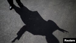 La sombra del presidente Donald Trump se refleja en el asfalto mientras conversa con un grupo de periodistas en los jardines de la Casa Blanca, en Washington D.C., el 27 de septiembre de 2017.