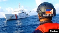 រូបឯកសារ៖ ឆ្មាំសមុទ្រ​ហ្វីលីពីន​ជិះ​ទូក​យាមល្បាត​ នៅ​ក្បែរ​នាវា​របស់​ចិន​ ដែល​គេ​ជឿ​ថា​បើ​ក​ដោយ​ក្រុម​យុទ្ធជន​ដែនសមុទ្រ​ចិន​នៅ​តំបន់​ថ្ម​ប៉ប្រះ​ទឹក Whitsun Reef ក្នុង​សមុទ្រ​ចិន​ខាង​ត្បូង ថ្ងៃទី១៥ ខែមេសា ឆ្នាំ២០២១។ 