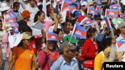 Garment workers shout and wave Cambodian national flags as they take part in a protest calling on the government to raise wages during a march to mark Labour Day in Phnom Penh May 1, 2015. (REUTERS/Samrang Pring) 