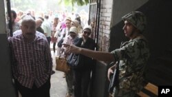 An Egyptian soldier directs a voter inside a polling station June 16, 2012 in Cairo, Egypt.