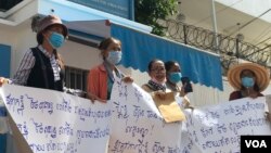 រូប​ឯកសារ៖ ក្រុមអ្នកតវ៉ា​លើក​បដានៅ​មុខ​ការិយាល័យ​ឧត្តមស្នង​ការ​អង្គការ​សហប្រជាជាតិទទួលបន្ទុក​សិទ្ធិមនុស្ស​នៅកម្ពុជា​ ថ្ងៃទី​១៩​ ខែ​មិថុនា​ ឆ្នាំ​២០២០ ស្នើឲ្យ​តុលាការ​ទម្លាក់​បទចោទ​ប្រកាន់​សាច់​ញាតិ​របស់​ពួកគេ​ ដែល​ជា​​អតីត​មន្ត្រី​គណបក្សប្រឆាំង​​។ (ហ៊ុល រស្មី​/វីអូអ)