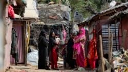 ជនភៀសខ្លួន​រ៉ូងហ៊ីងយ៉ា​ឈរ​នៅ​ខាង​ក្រៅ​ជំរំ​របស់​ពួកគេ​ដែល​ស្ថិត​នៅ​ជាយ​ក្រុង Jammu ប្រទេស​ឥណ្ឌា ថ្ងៃទី៧ ខែមីនា ឆ្នាំ២០២១។