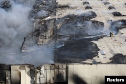 Petugas pemadam kebakaran berupaya memadamkan api di lokasi serangan rudal Rusia di Odesa, Ukraina, 24 Juni 2024. (REUTERS/Stringer)