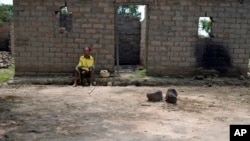 Julienne Mbetidemo sits outside the remains of her home, burned by Seleka rebels, in the village of Ngangue, 10 kilometers (6 miles) from Mbres, Central African Republic, July 27, 2013.