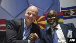 Le président de la FIFA, Gianni Infantino, serre la main du président de la fédération nigériane Amaju Pinnick lors d'une conférence de presse à l'issue du sommet exécutif de la FIFA à Lagos, le 20 février 2018.