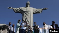 Brazil's Environment Minister Ricardo Salles, accompanied by authorities and clergy, cuts a ribbon during the reopening ceremony of the Christ the Redeemer statue, in Rio de Janeiro, Brazil, Aug. 15, 2020. 