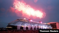 People watch 'float out' of newly built cruise ship Disney Dream at the Meyer shipyard in Papenburg, June 28, 2021.