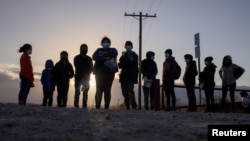 Migrantes en busca de asilo de América Central esperan transporte después de cruzar el río Grande hacia los Estados Unidos desde México en una balsa en Peñitas, Texas, el 12 de marzo de 2021.