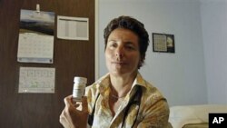 Dr. Lisa Sterman holds a bottle of Truvada pills that she prescribes for about a dozen patients at high risk for developing AIDS, at her office in San Francisco, May 20, 2012.