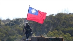 FILE - A soldier holds a Taiwanese flag during a military exercise aimed at defending from an attack from China, Jan. 19, 2021, in Hsinchu County, northern Taiwan.