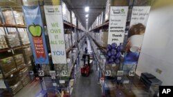 Pallets of various foods are stacked on shelves in the extensive warehouse at the Houston Food Bank Wednesday, Oct. 14, 2020, in Houston. (AP Photo/Michael Wyke)
