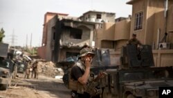 An Iraqi special forces soldier speaks on the radio as troops move from the Yarmouk neighborhood to take another district from Islamic State militant control in Mosul, Iraq, April 12, 2017. 