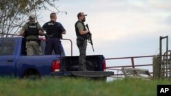 Agentes de policía sostienen rifles mientras investigan una escena, en Bowdoin, Maine, el 26 de octubre de 2023, durante la búsqueda del sospechoso de los tiroteos masivos mortales en Lewiston, Maine, el día anterior. 