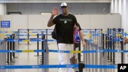 Former NBA basketball player Dennis Rodman gestures to photographers as he prepares to go through immigration at Beijing Capital International Airport in Beijing, June 13, 2017.