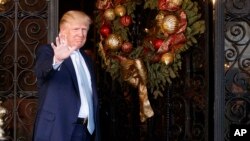 President-elect Donald Trump stands at the entrance of Mar-a-Lago and waves to reporters after meeting with Carlyle Group co-founder and co-CEO David Rubenstein, Wednesday, Dec. 28, 2016, in Palm Beach, Florida. 