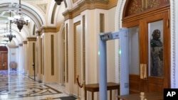 FILE - Members of the House of Representatives must now pass through a security check with metal detectors before entering the chamber, a new safety measure put into place after a mob stormed the Capitol January 6, in Washington, Jan. 27, 2021. 